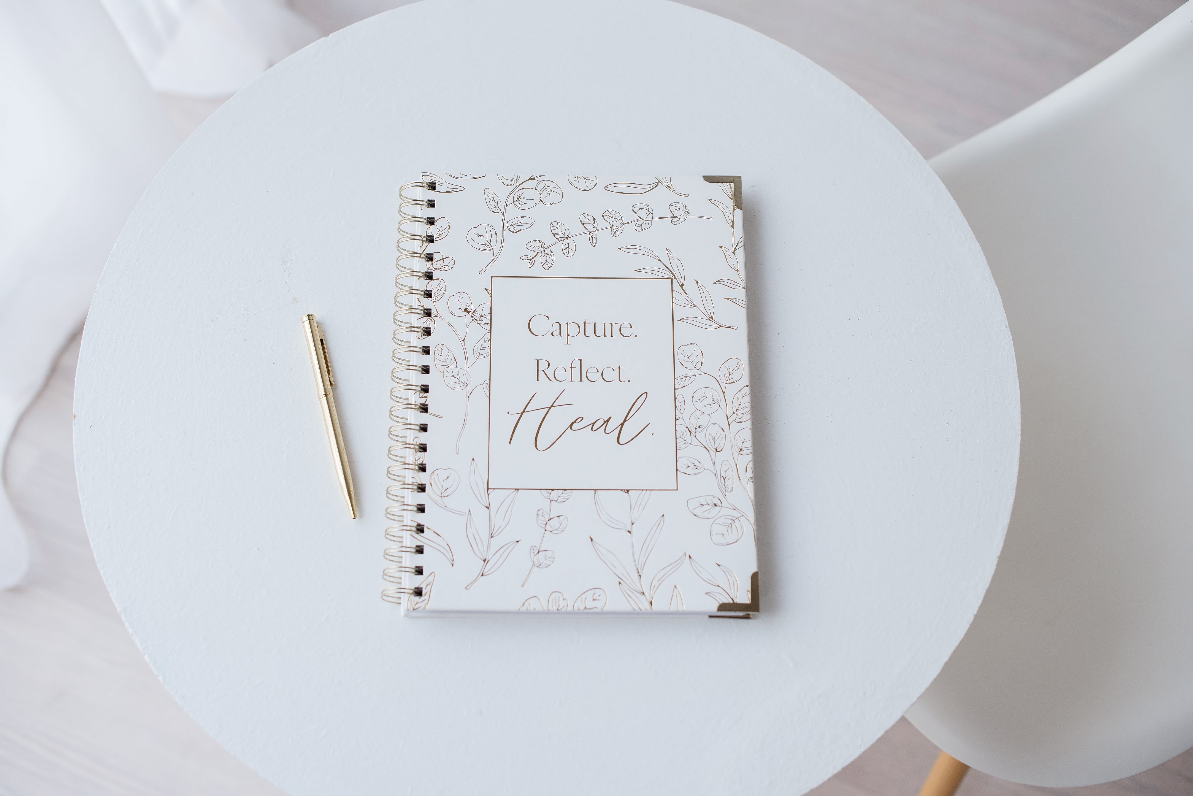 Christian grief journal for pregnancy loss and miscarriage on a white table with a gold pen